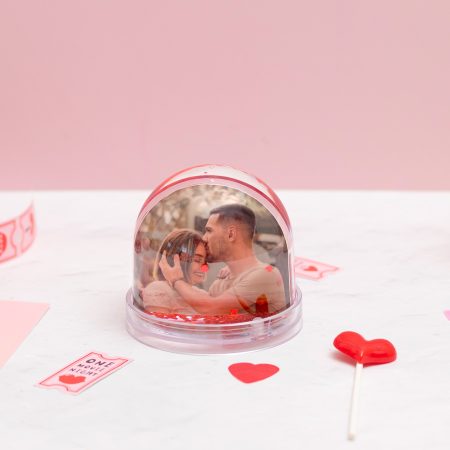 Bola de nieve con corazones flotando en su interior